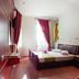 Splanzia Boutique Hotel in Chania, guest room with double bed, red curtains, wood floor, and wall art