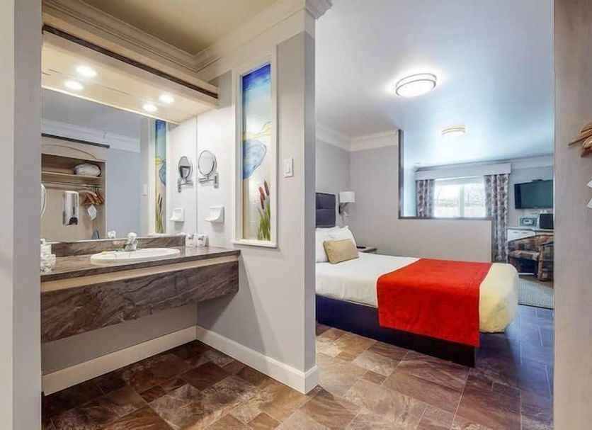 Auberge l'Ambassadeur in Amqui: guest room with vanity and bedroom area