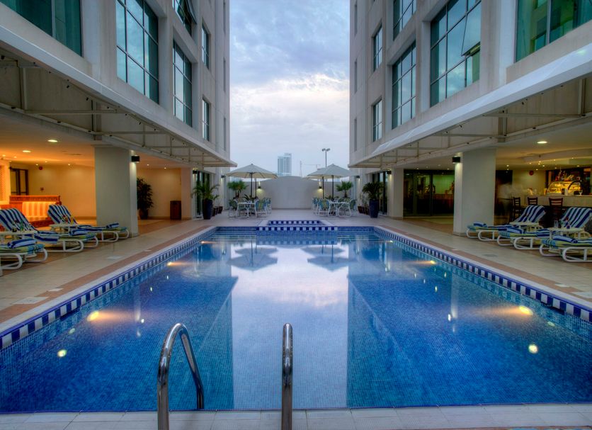 Siji Hotel Apartments in Fujairah pool courtyard between modern buildings with lounge chairs