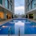 Siji Hotel Apartments in Fujairah pool courtyard between modern buildings with lounge chairs