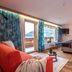 Hotel Tipotsch in Stumm guest room with balcony, mountain view, bed, sofa and TV