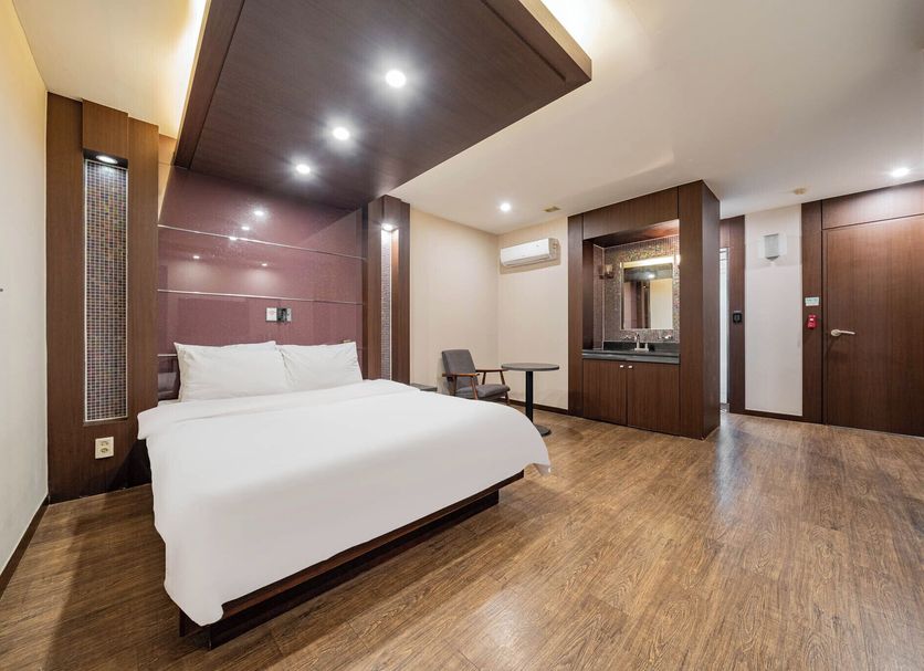 Incheon Airport Hotel June room with queen bed, wood floors, desk and wall mirror in Incheon