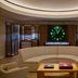 Four Seasons Resort Lanai lobby lounge with curved sofa, glowing clock, and wood cabinetry in Lanai City