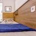 Pousada Soft Brooklin room in Sao Paulo with single bed, blue throw, and bathroom doorway