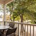 Club Wyndham at The Cottages in Myrtle Beach: covered porch with table, chairs, and tree-lined view