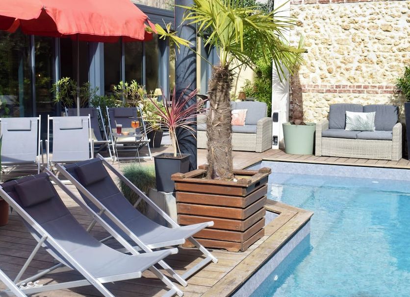 Le Trophée Boutique Hôtel Spa- La Loggia Appart'hôtel in Deauville: poolside loungers beside outdoor pool