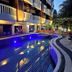 Ratana Hill Patong in Patong: curved outdoor pool beside balconies and lounge chairs at dusk