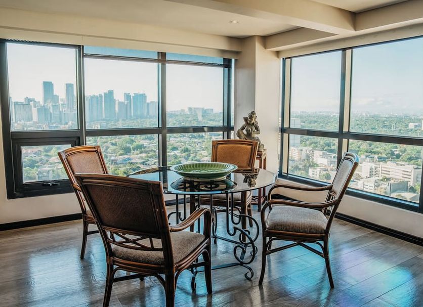1898 Hotel Colonia En Las Filipinas in Makati, high-rise suite with city skyline views and seating area