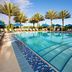 Hilton Grand Vacations Club Parc Soleil Orlando pool with palm trees, blue umbrellas and loungers