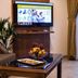 Umm Al Quwain Beach Hotel lounge with sofa, TV, coffee table and fruit bowl in Umm Al Qaiwain