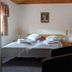 Engimyri Lodge in Akureyri bedroom with double bed, bedside lamps, chair, and wall mirror