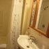 Windjammer By The Sea Hampton bathroom with shower, sink, mirror, and floral shower curtain