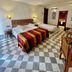 Alcoba del Rey de Sevilla room with twin beds, ornate ceiling medallion and checkered tile floor in Seville