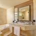 Grand Palladium Bavaro Suites Resort & Spa bathroom with tub, glass shower, vanity and mirror in Punta Cana