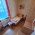 Zur Rotenfelsstube in Norheim: cozy single room with twin bed, chair, and wood furniture by a window.