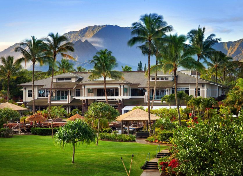 The Westin Princeville Ocean Resort Villas in Princeville with palm trees, lush lawn and mountain backdrop