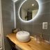Hôtel La Maison des Dunes bathroom in Erdeven with round vessel sink, lit mirror, and wooden vanity