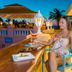 Amsterdam Manor Beach Resort in Noord: woman relaxing at rooftop bar with ocean sunset view