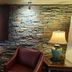 Red Roof Inn & Suites Cornelius - Lake Norman lobby seating area with stone wall and table lamp