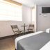 B&B Wasi Airport Lima guest room in Lima with two beds, wall-mounted TV, and seating area