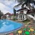 Seulawah Resort And Cafe in Batu with outdoor pool, palm trees, and a dolphin sculpture by the patio