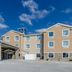 Cobblestone Hotel & Suites - Mccook exterior with covered entrance under a blue sky