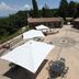 Agriturismo Lapone in Orvieto with a stone courtyard, white umbrellas, and outdoor dining tables