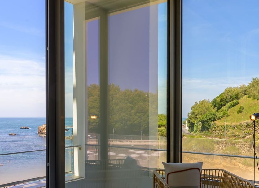 Hotel de La Plage Biarritz room with balcony chairs and ocean view through glass doors