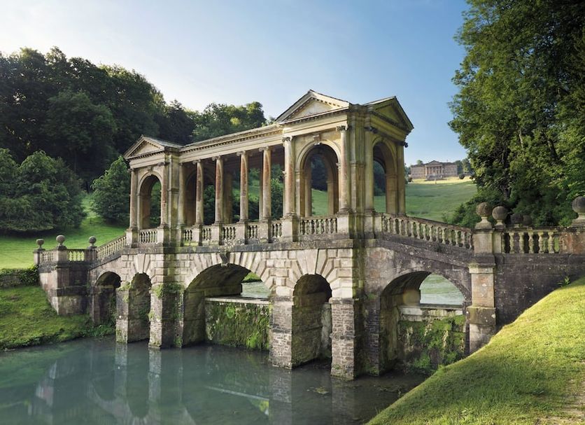 Royal Hotel Bath near stone bridge pavilion over water, surrounded by lush greenery