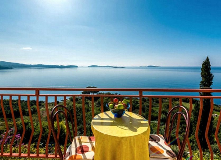 Guest House Fontana in Mlini with balcony sea view, table and chairs overlooking calm blue water