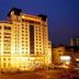 Binhai Jianguo Hotel in Tianjin lit up at night, showing a tall city hotel exterior