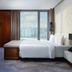 Minsk Marriott Hotel room with king bed, city view window, and lounge bench in Minsk
