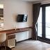 Campagne Hotel And Residence - Sha Plus room with desk, wall-mounted TV and balcony door in Pathum Thani