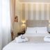 Hotel Villa Tiziana in Marina di Massa guest room with double bed, striped accent wall and mirror