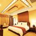 White Dolphin Hotel in Qinzhou guest room with king bed, sofa seating, and ornate ceiling lighting