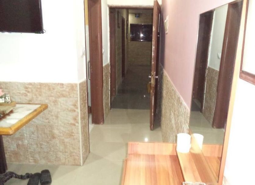 Amman Palace Hotel in Amman hallway with open doors, tiled walls, and a small table