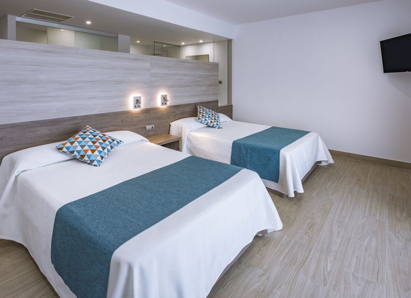 4R Gran Europe, Coma-ruga: twin guest room with two beds, teal runners, and wall-mounted TV