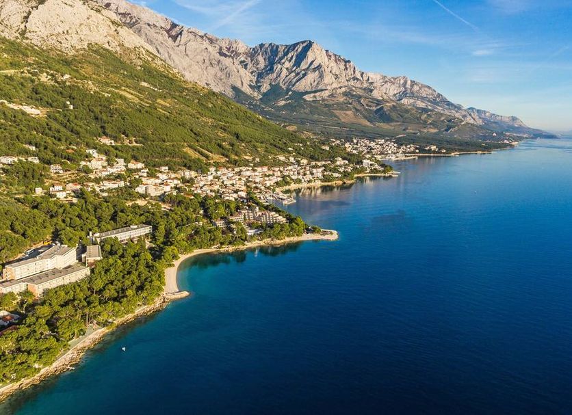 Bluesun Hotel Marina in Brela overlooking a scenic blue bay, coastline, and mountain backdrop.