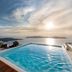 Vallas Apartments & Villas in Firostefani with an infinity pool overlooking the sea at sunset