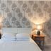 Woodcote Hotel in Ellesmere Port bedroom with double bed, matching bedside lamps and patterned wallpaper