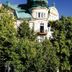 Grand Hotell Hörnan in Uppsala, historic facade with green roof behind leafy trees