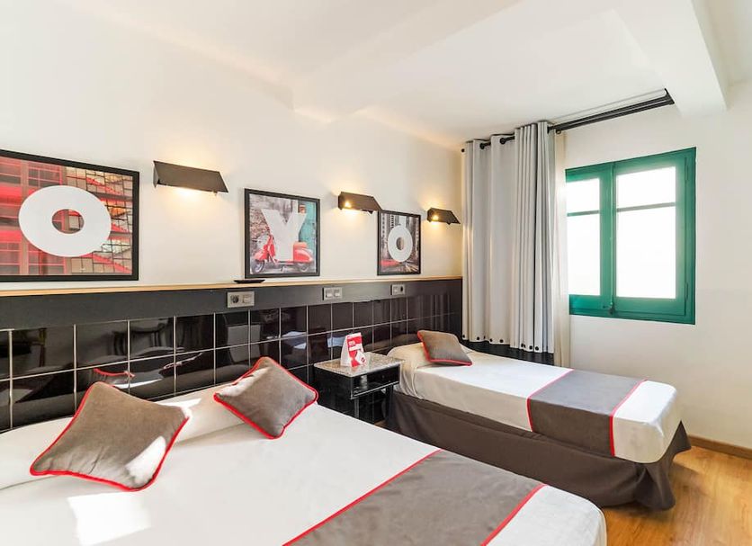 Hostal Athenas in Sant Adrià de Besòs offers a twin room with two beds, wall art, and a window.