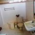 Bali Lovina Beach Cottages bathroom in Buleleng with toilet, sink, mirror, and tiled shower area