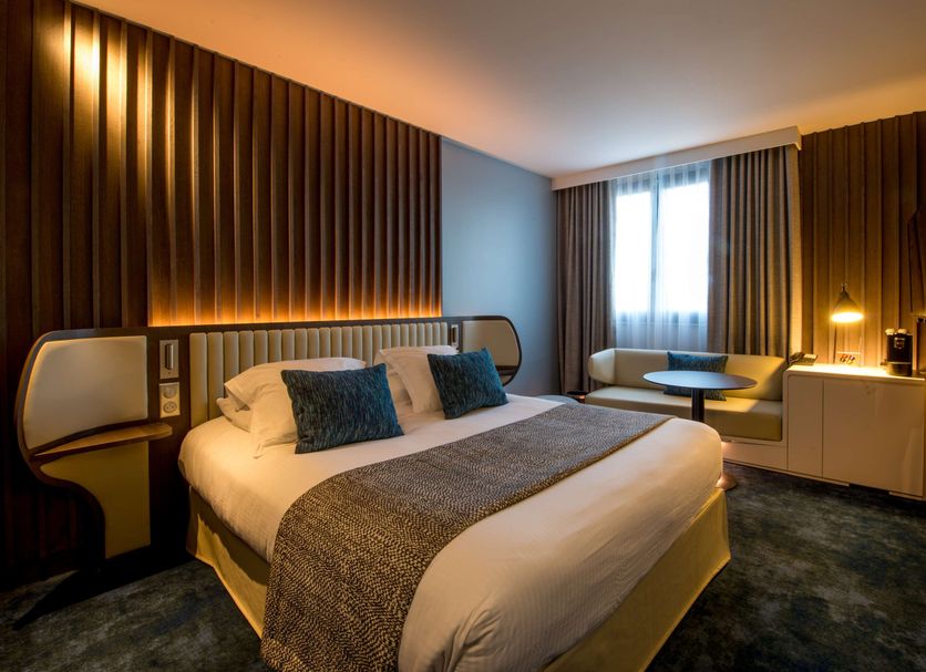 Best Western Premier Hotel de la Paix room in Reims with king bed, window seating and warm lighting