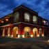 Tenuta Cavalieri in Leverano, illuminated red hotel exterior with arched windows and landscaped entrance