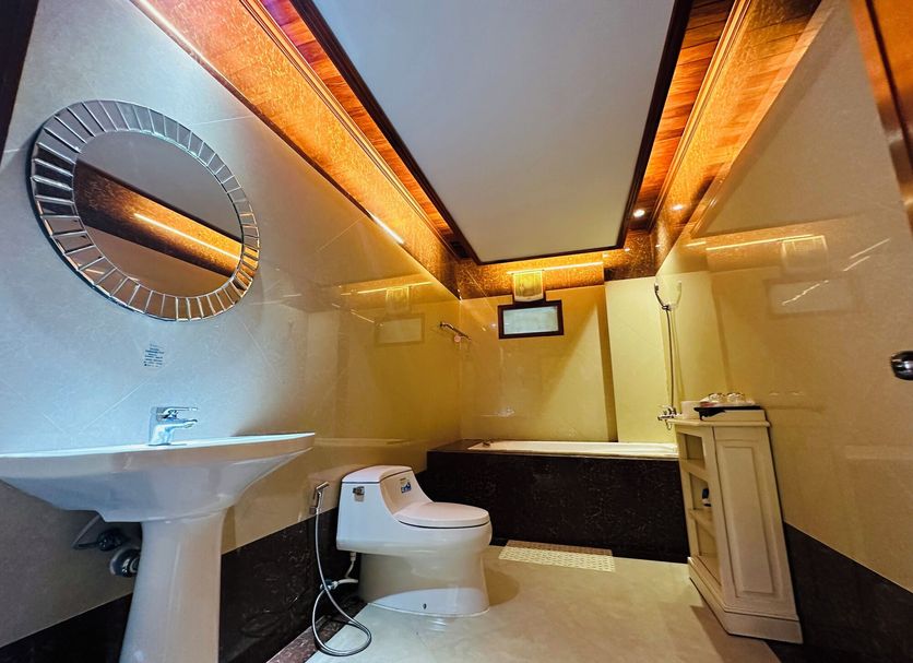 Villa Phonethip Mekong Riverside bathroom with pedestal sink, toilet, soaking tub and ceiling lighting