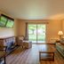 Parkwood Lodge in Fish Creek living room with sofa, armchair, fireplace, TV, and sliding glass door to patio