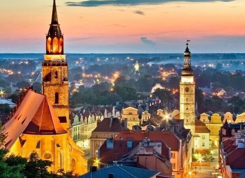 Protea, Bolesławiec: twilight cityscape with illuminated church towers and rooftops