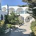 Hotel Lodos in Karterados, white-and-blue courtyard with arched balconies and garden walkway