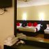 Katero in Pokhara hotel room with twin beds, red pillows, wall TV, mirror and folded towels